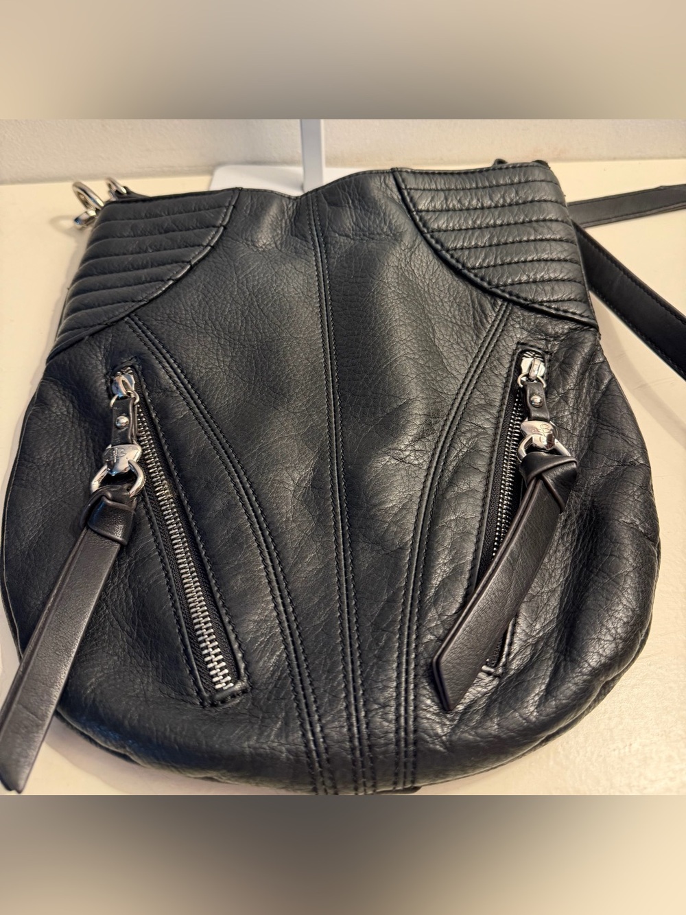 B. Makowski black leather crossbody with zipper detail.